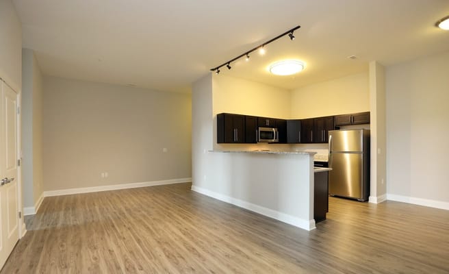 Open living room space with kitchen view in Linden Hill Station Apartments.