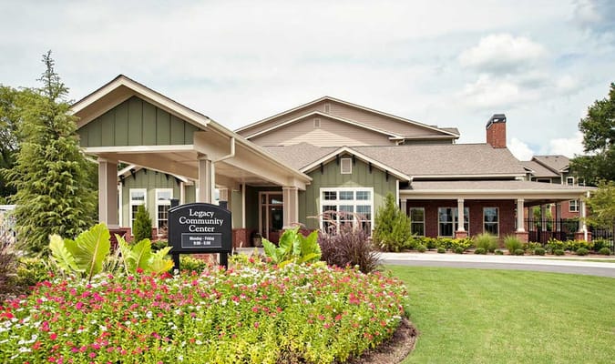 Front view of the Legacy Community Center surrounded by flowers.
