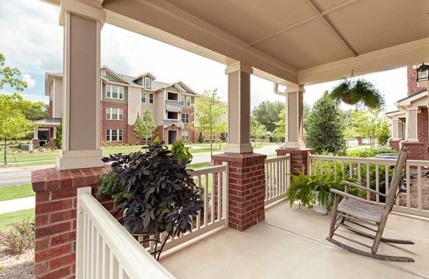 Porch with rocking chair overlooking landscaped grounds and buildings