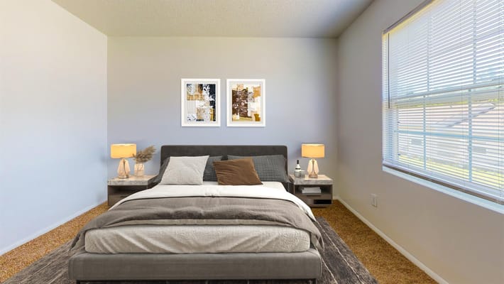 Well-furnished bedroom with a bed, decorative pillows, and natural light.