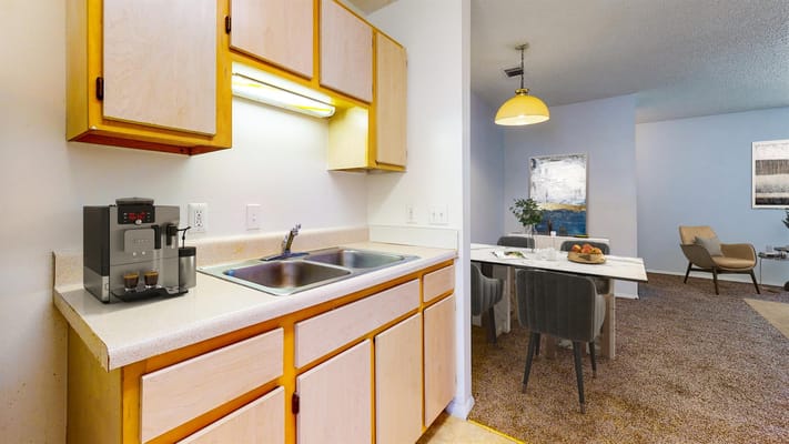 Kitchen with coffee machine and dining area in a senior living apartment