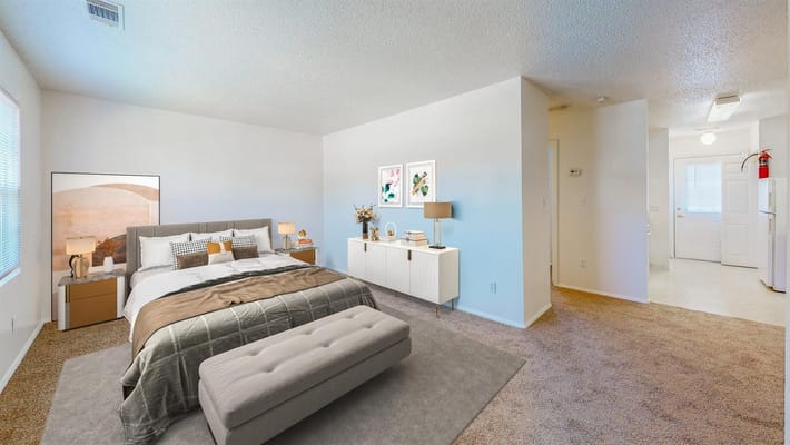 Spacious bedroom with a bed, side tables, and a stylish dresser.