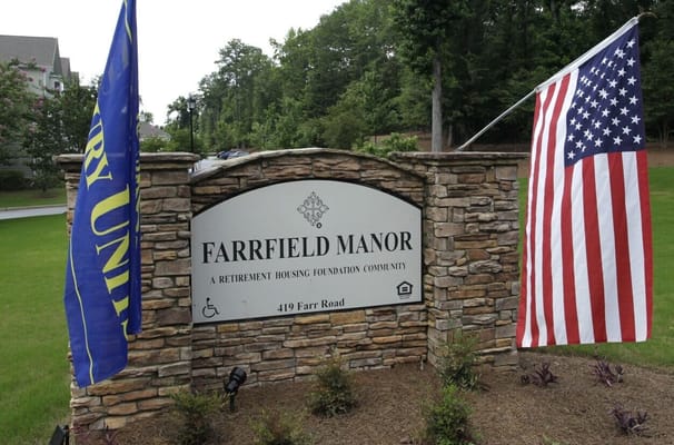 Sign for Farrfield Manor Senior Apartments with flags