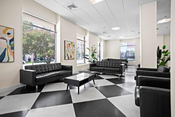 Contemporary lounge with black leather sofas and decorative art