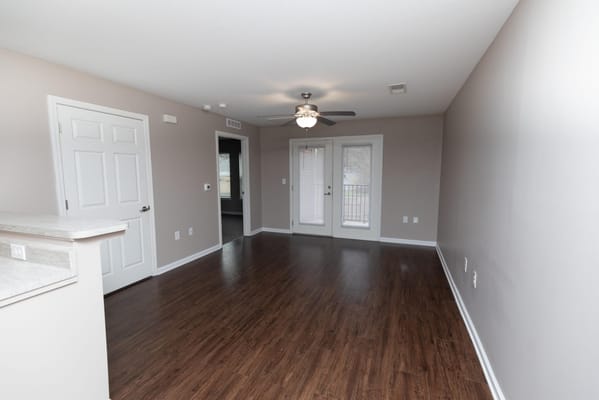Bright and spacious living room with ceiling fan and patio doors