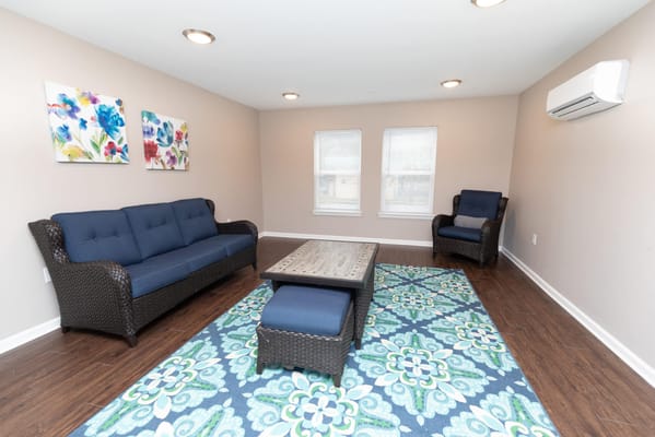 A cozy living room with a blue sofa and artistic wall decor