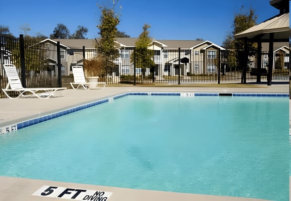 A swimming pool area with residential buildings in the background