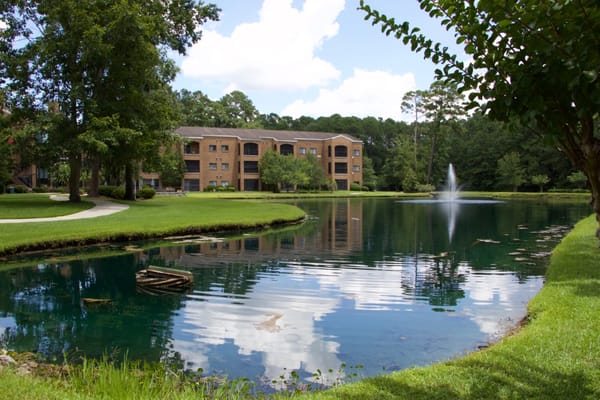 Exterior view of Magnolia Manor with pond and trees