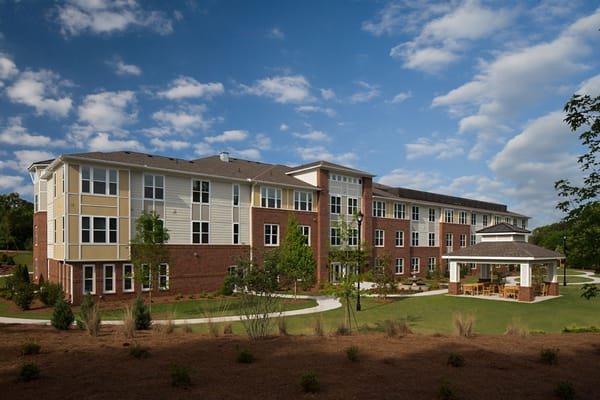 Exterior view of a senior living facility with outdoor seating