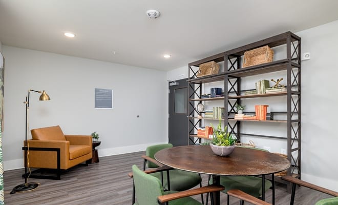 Interior view of a cozy common area with seating and bookshelves