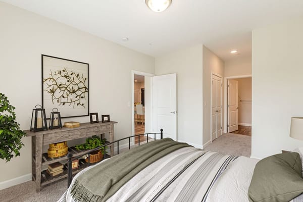 Cozy bedroom featuring a bed, decorative art, and a console table