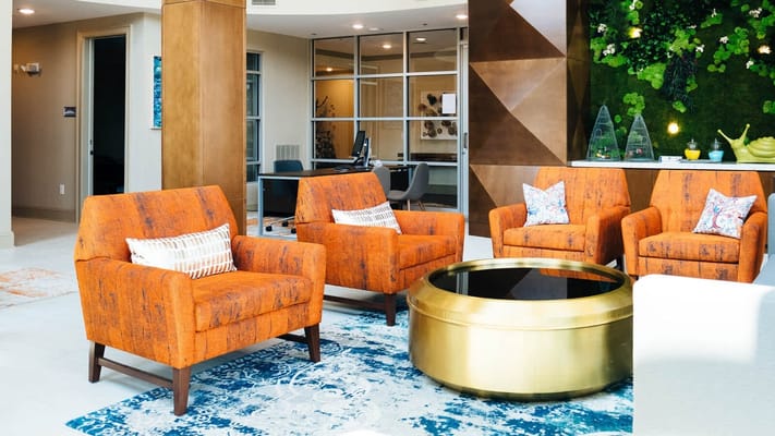 Bright and modern common area with orange chairs
