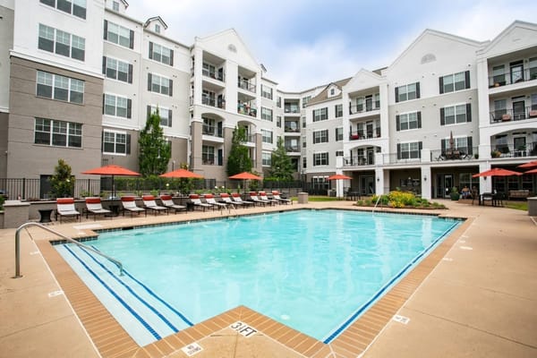 Outdoor pool area with lounge chairs at Emblem Alpharetta