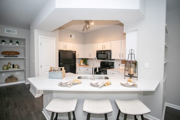 Modern kitchen interior with white cabinets and bar seating