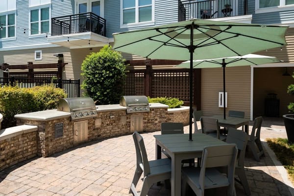 Outdoor grilling area with tables and umbrellas