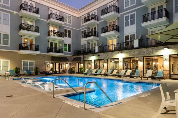 Swimming pool area with lounge chairs in a senior living facility