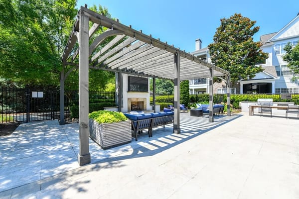 Outdoor seating area with shaded pergola and plants