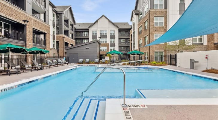 Outdoor pool area with lounge chairs and umbrellas