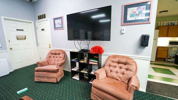 Comfortable seating area with two chairs and a large TV