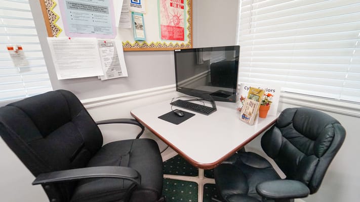 A computer station with two chairs and a monitor