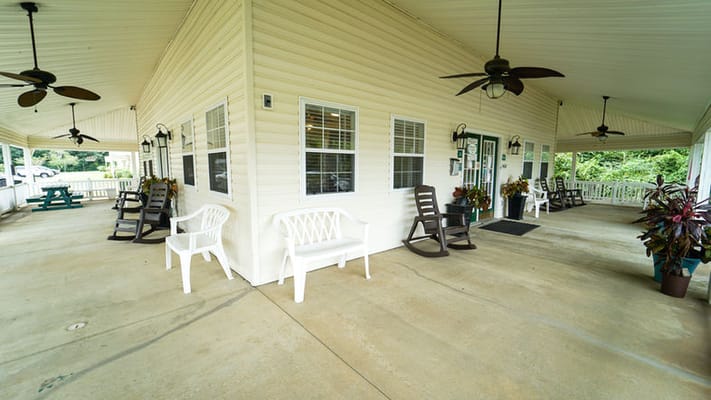 Covered porch with seating and plants at Albany Spring Seniors