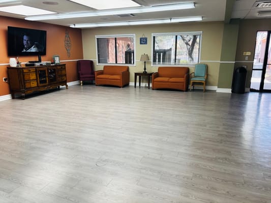 Bright interior common area with seating and TV.