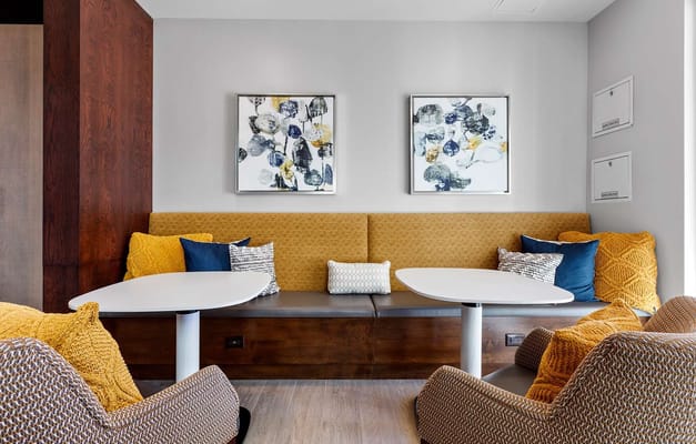 A cozy common area featuring yellow and blue cushions on a bench
