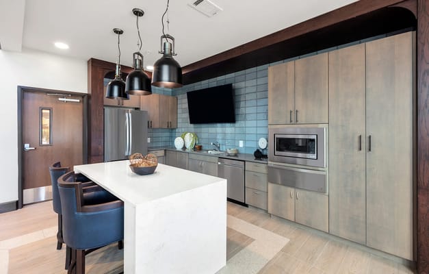 A modern kitchen featuring sleek cabinets and stylish lighting fixtures.