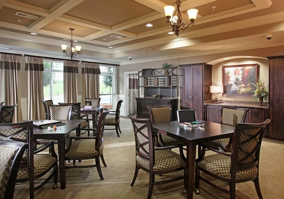 Interior of a common area featuring tables and chairs at HearthSide Brookleigh.