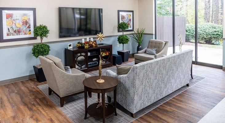Comfortable seating area with a TV and decorative plants.