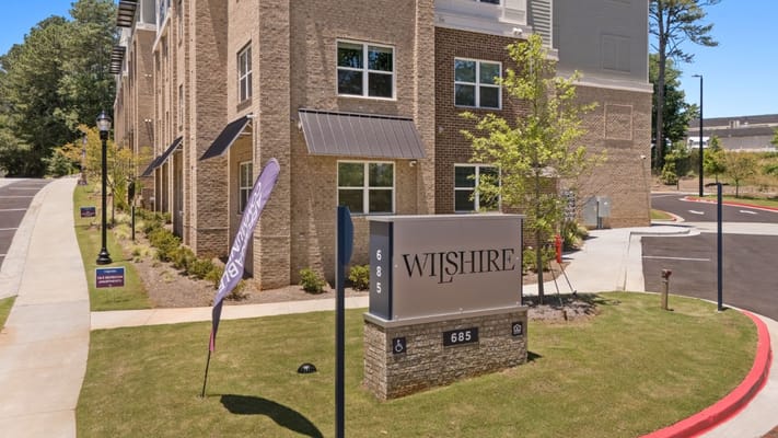 Exterior view of Wilshire Senior Apartments building with signage