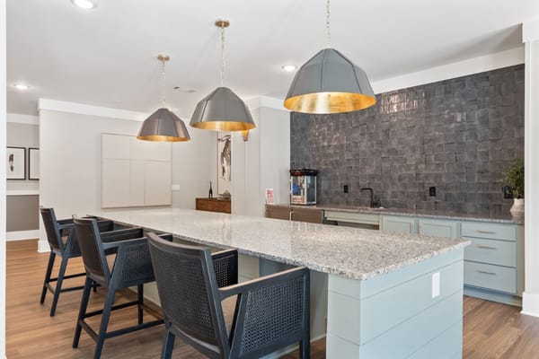 Modern kitchen area with seating and pendant lights