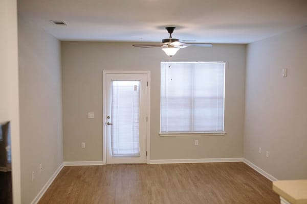Empty interior room with a ceiling fan and window