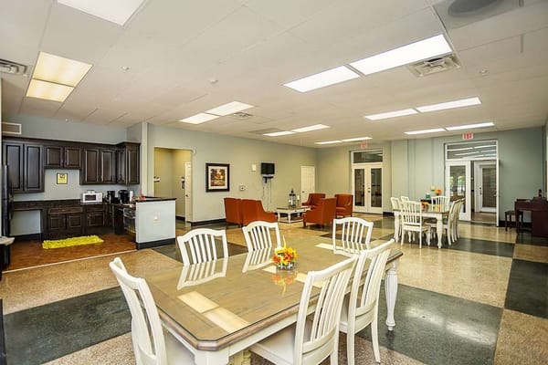 Bright common area with dining tables and kitchen