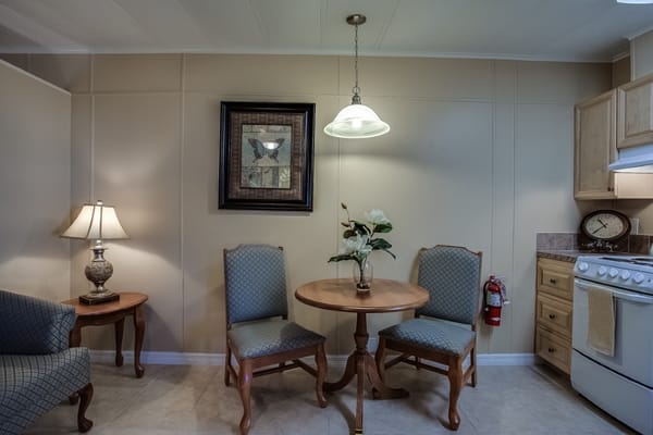 Small dining area with a table, two chairs, and a lamp.