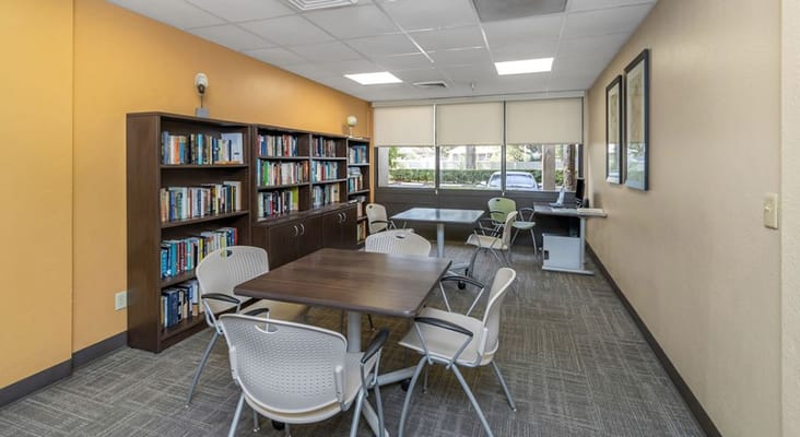 Common area with bookshelves and tables at Mary Walker Senior Apartments.