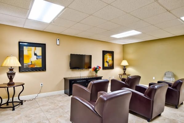 Cozy lounge area with leather chairs and a TV