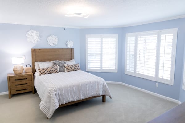 Bright and inviting bedroom with twin windows and stylish decor.