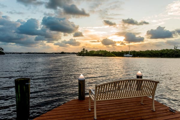 Empty bench overlooking the water with a sunset