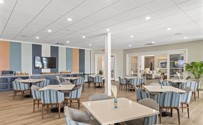 Bright dining area with tables and chairs arranged.