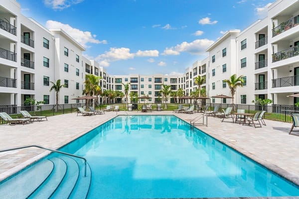 Pool area with lounge chairs and landscaped surroundings