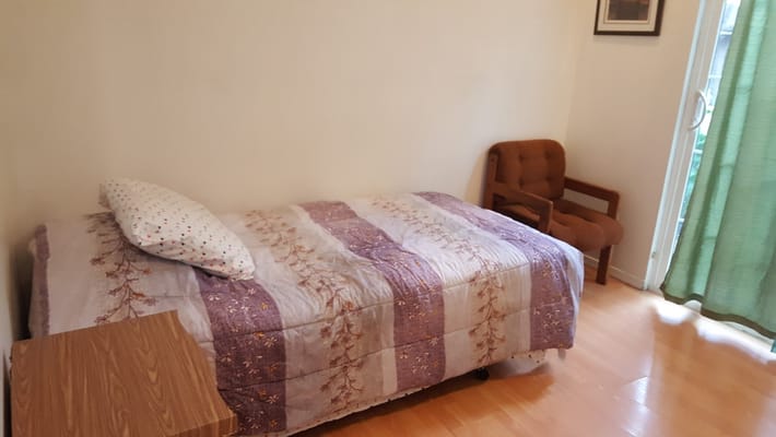 Private resident room with a bed and chair