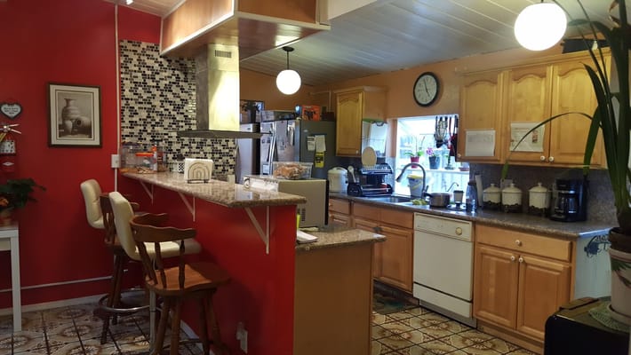 Interior kitchen area with bar stools and appliances