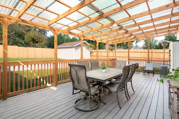Patio with dining table and chairs under a wooden pergola
