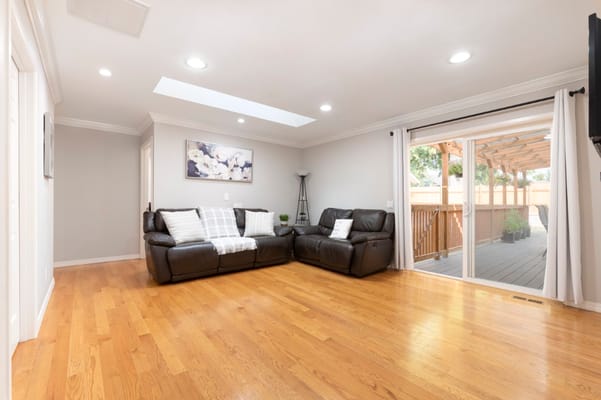 Spacious living room with leather sofas and a view of the outdoor patio.