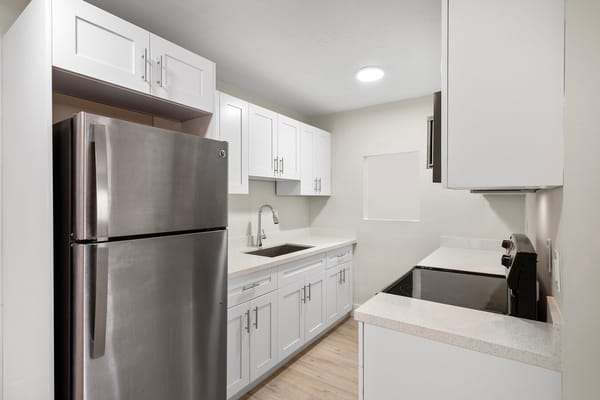 Modern kitchen with white cabinets and stainless steel appliances