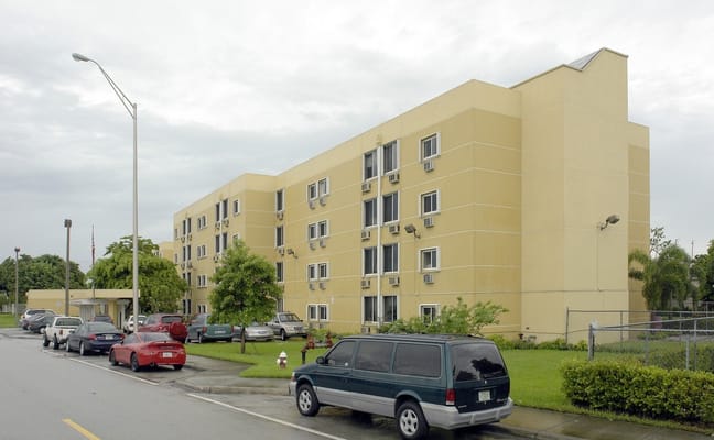 Exterior view of a residential building with vehicles parked