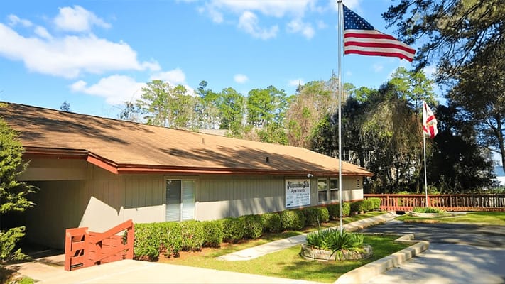 Exterior view of Miccosukee Hills Apartments with flags