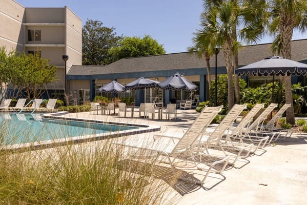 Outdoor pool area with lounge chairs and umbrellas