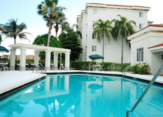 Outdoor swimming pool surrounded by palm trees